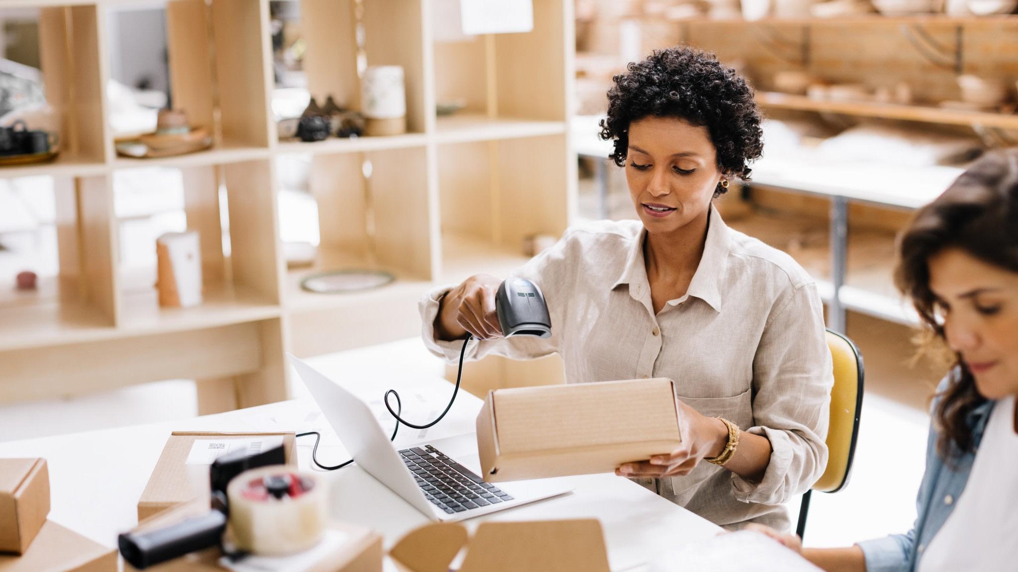 Online store owner scanning the barcode of a package box in a warehouse