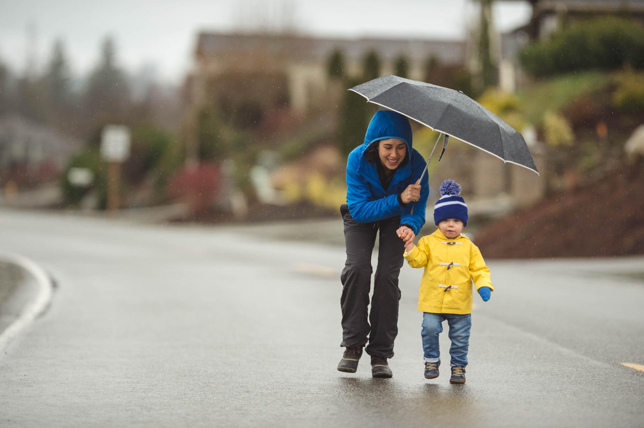 Mother and child in the rain under an umbrella.