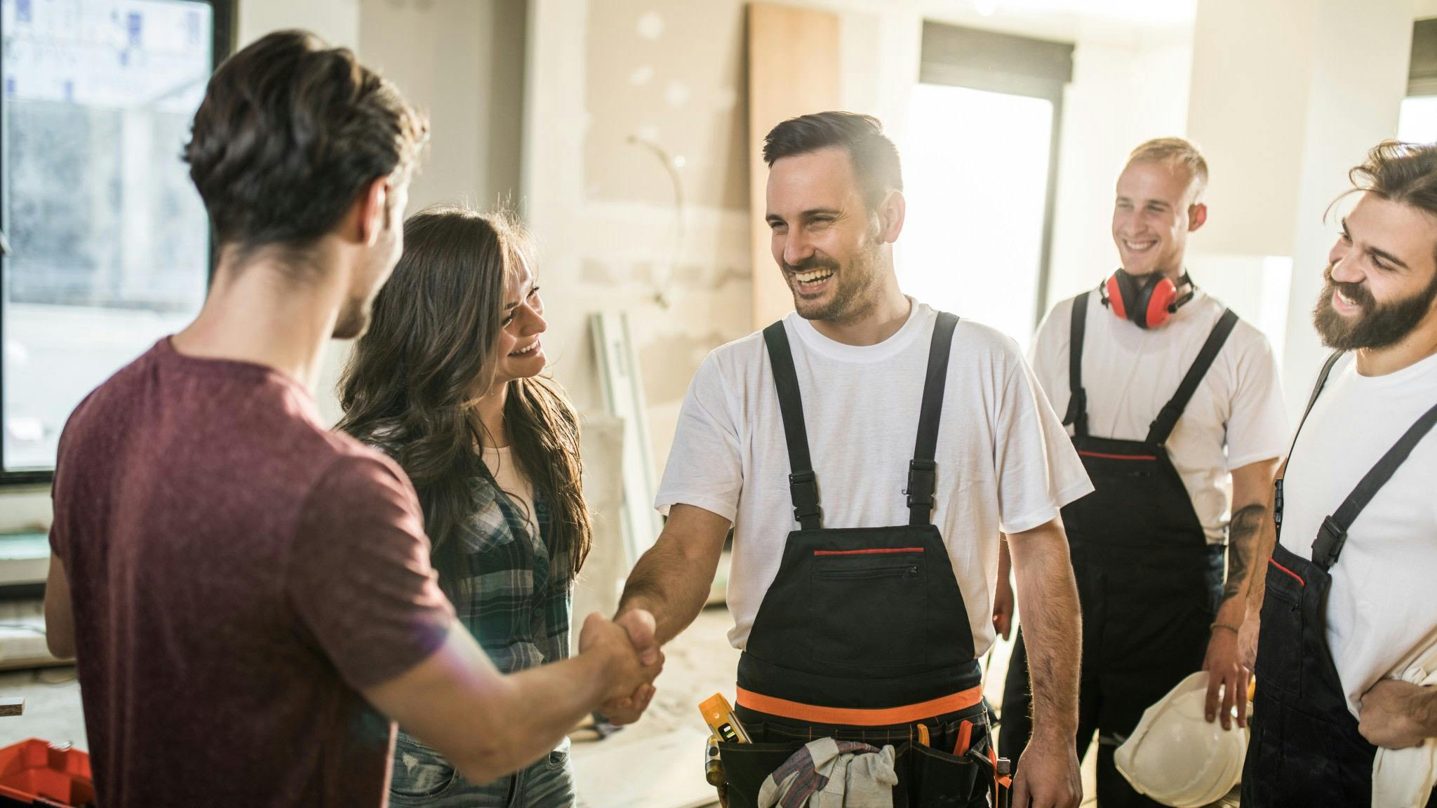 Happy couple meeting construction crew.