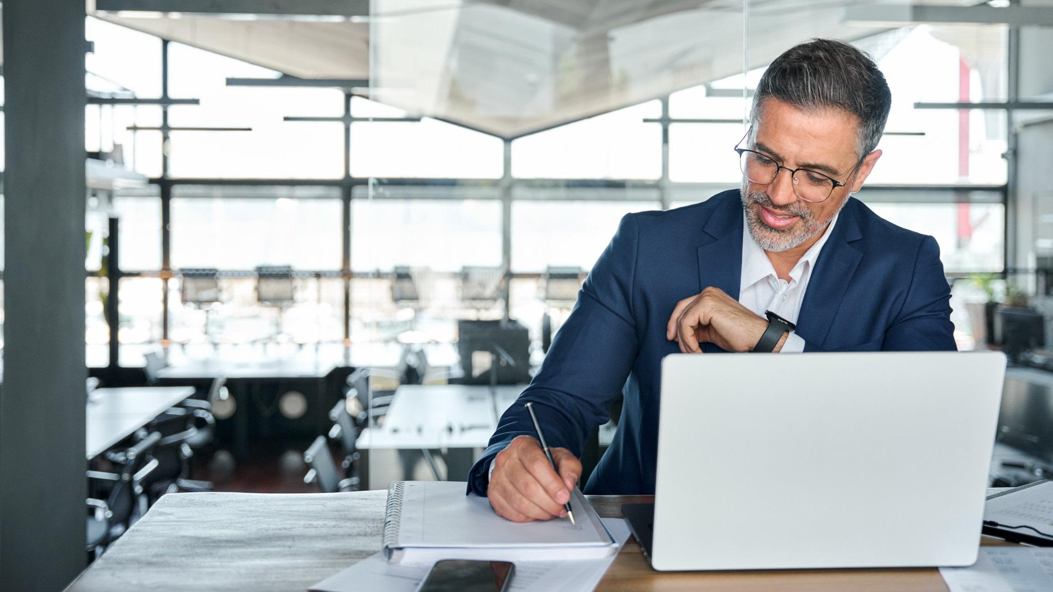 Businessman sitting down at a desk and working out their finances.