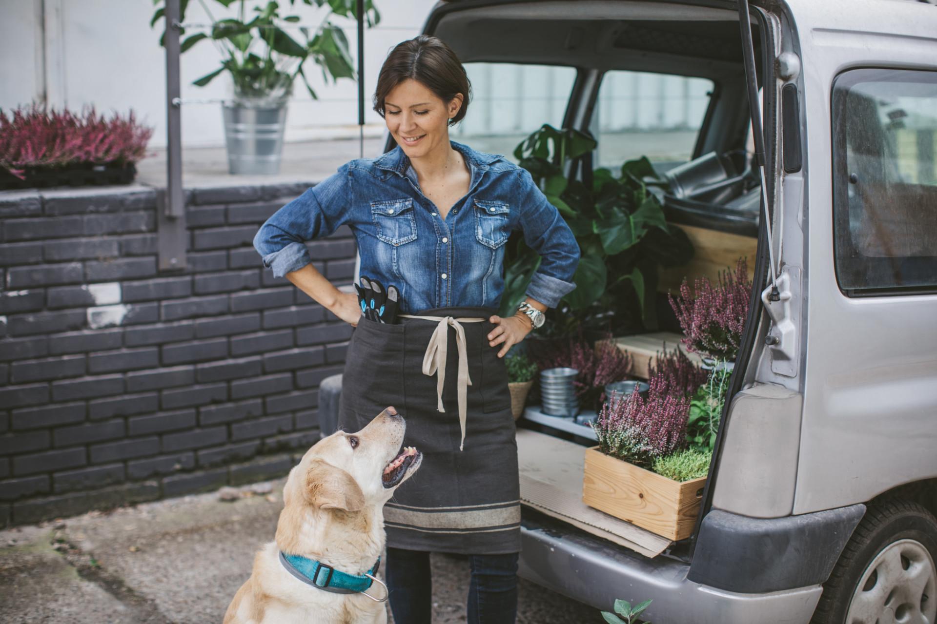 Woman with dog outside of van.