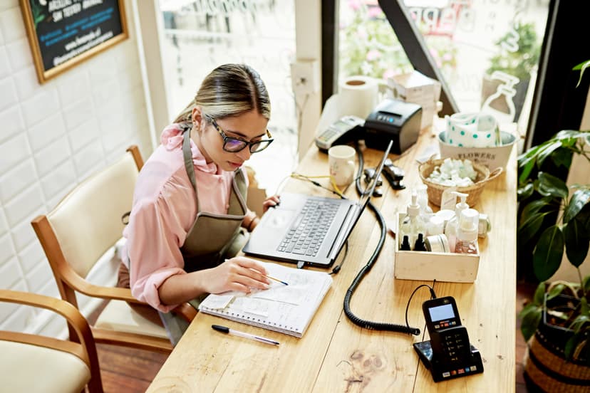 Young business owner using laptop in retail shop